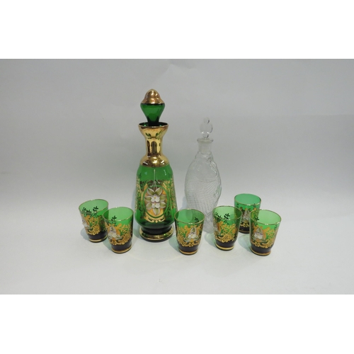 4400 - An Italian green glass decanter with six glasses, gilt embellishment and a moulded glass fish bottle... 