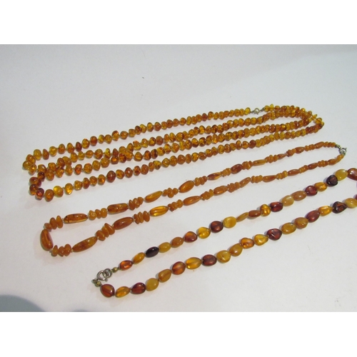 4352 - An opera length string of amber beads and two further examples (3)