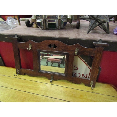 4013 - An early 20thC oak wall mirror/coat hooks, 35cm x 75cm