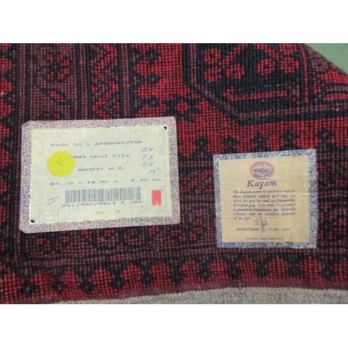 4017 - An Afghanistan Kayam red ground wool rug, multiple borders, tasselled ends, 80cm x 65cm