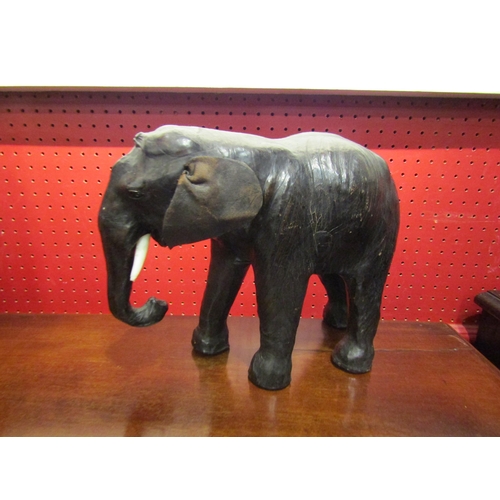 4024 - A leather elephant, rear leg a/f, 22cm high x 28cm long