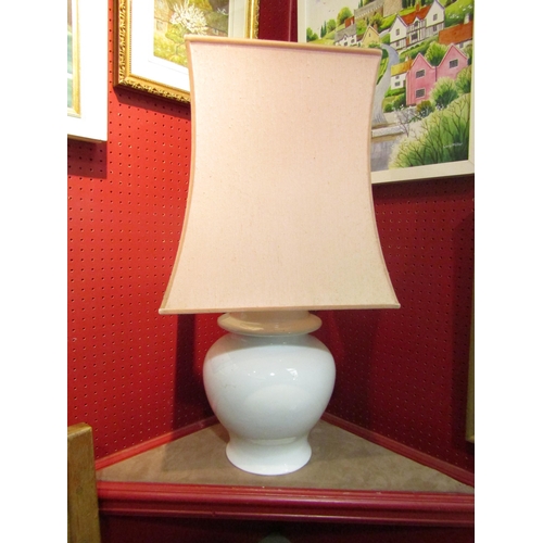 4048 - A white bulbous form table lamp of Chinese influence with a pale pink silk shade