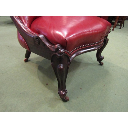 4091 - A circa 1860 mahogany and red leather button-back armchair with carved decoration, the serpentine fr... 