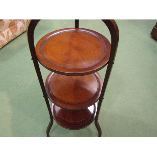 4104 - An Edwardian line inlaid mahogany three tier cake stand in the manner of 