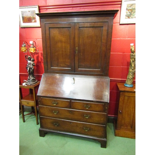 4123 - A circa 1800 George III country oak bookcase bureau, the two door cupboard with key over a fitted in... 