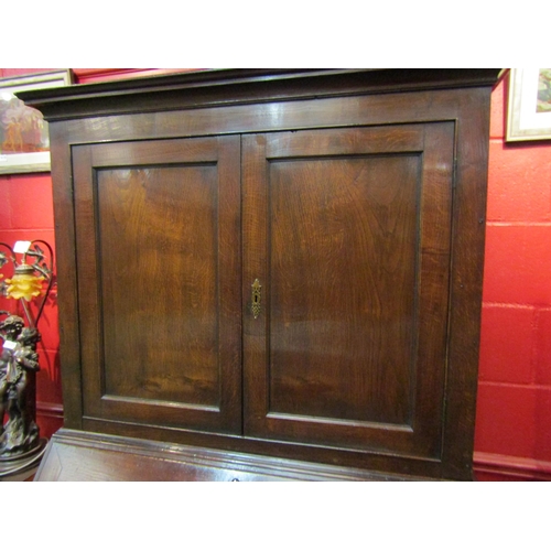 4123 - A circa 1800 George III country oak bookcase bureau, the two door cupboard with key over a fitted in... 