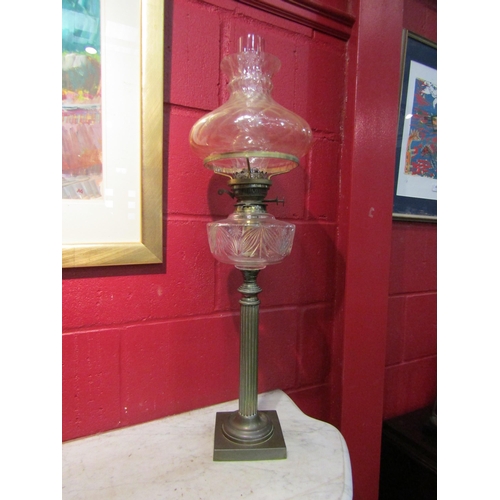 4144 - A Victorian oil lamp, the peach tinted shade over a clear cut glass reservoir, to a reeded column, s... 