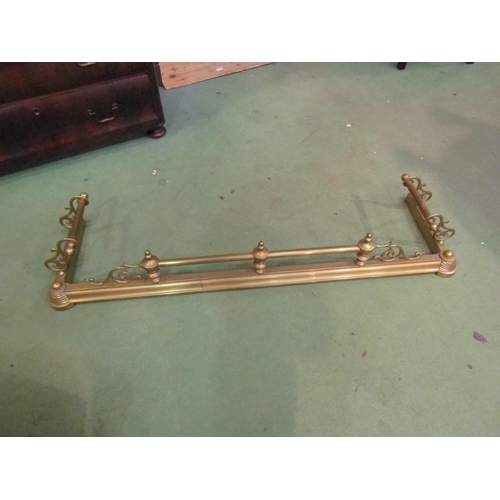 4146 - An ornate brass fire fender with scrolled supports and finials, 130cm long x 36cm deep   (R) £20