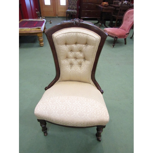 4155 - A walnut mid Victorian button-back armchair with carved relief, the bow front seat over turned and t... 