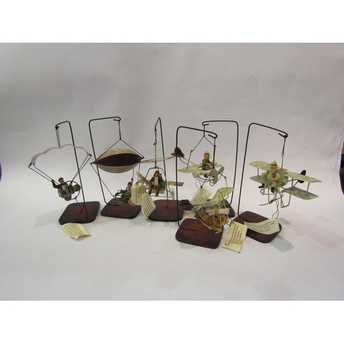 4204 - Six hanging metal models of Heath Robinson style aircraft, on stands