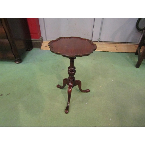 4205 - A George III style mahogany wine table the piecrust edge top over a turned and fluted column on a tr... 