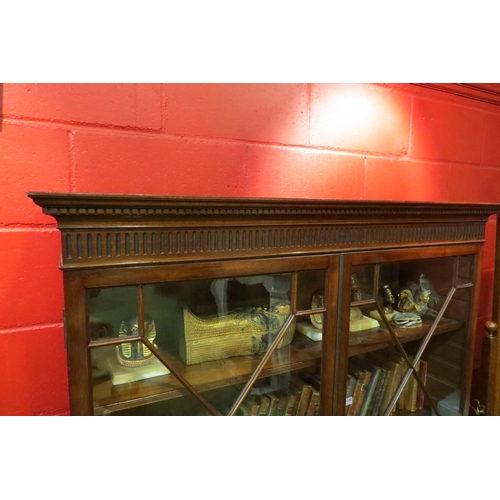 4128 - A Georgian flame mahogany astragal glazed two door bookcase with height adjustable shelves and key o... 