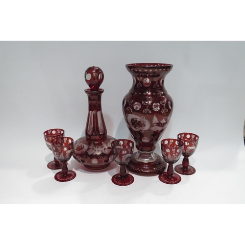 4436 - A set of red Bohemian glassware with city and floral scenes comprising vase, decanter and set of fiv... 