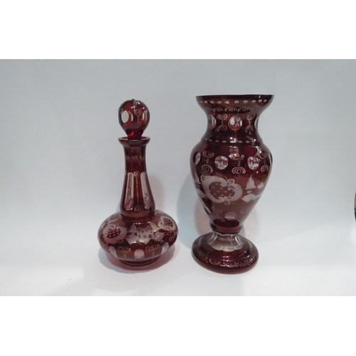 4436 - A set of red Bohemian glassware with city and floral scenes comprising vase, decanter and set of fiv... 