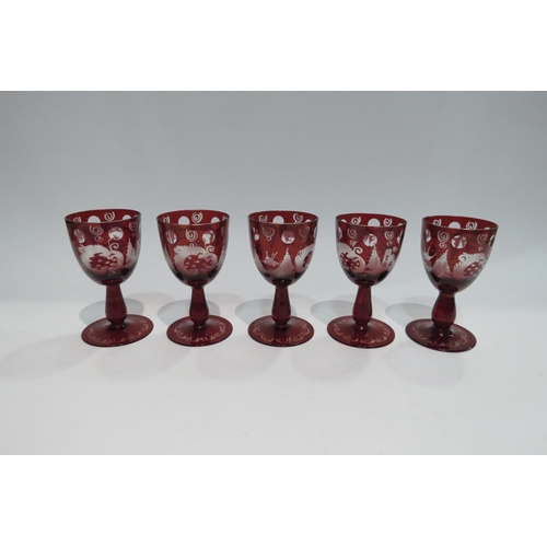 4436 - A set of red Bohemian glassware with city and floral scenes comprising vase, decanter and set of fiv... 