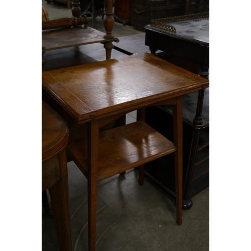 2183 - An early 20th Century light oak occassional table, fold-over top, with undertier