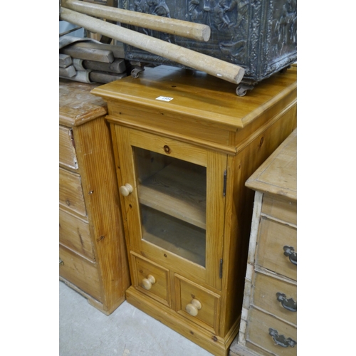 2309 - A pine cupboard, single glazed door over twin doors, plinth base