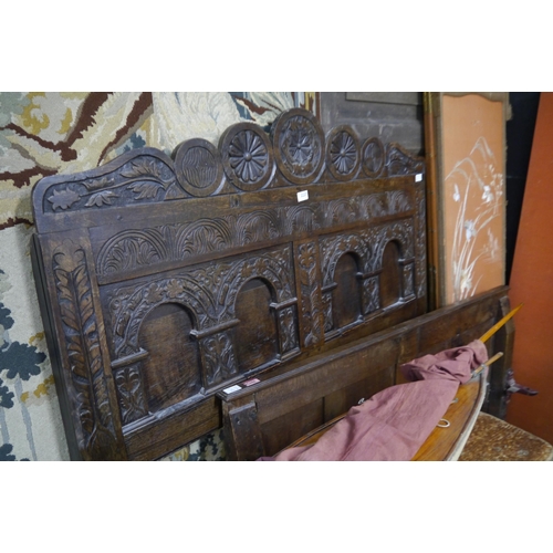 2337 - A Jacobean panelled oak bed base with irons and slats