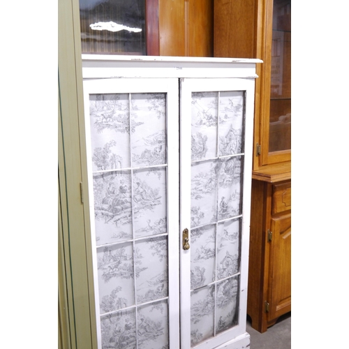 2344 - An old French white painted glazed two door cupboard with fabric panels