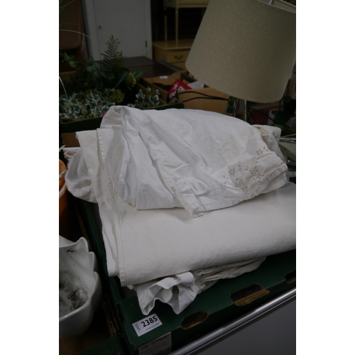 2385 - A box of assorted linen and lace, including sheets, clothes