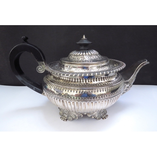 6357 - A William Fountain silver teapot embossed foliate borders, reeded half body, raised on four scroll c... 