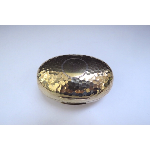 6438 - An Albert Barker Ltd silver gilt hinged ovoid shaped box with hammered decoration, circular cartouch... 