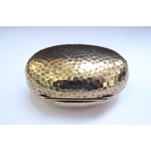 6438 - An Albert Barker Ltd silver gilt hinged ovoid shaped box with hammered decoration, circular cartouch... 