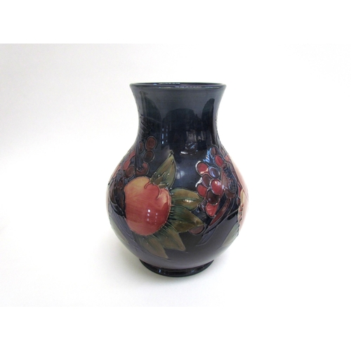 6271 - A Moorcroft Finches and Berries on blue pattern vase, 24cm tall