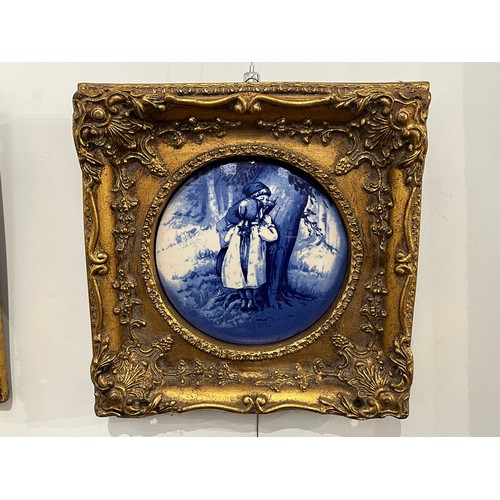 6014 - Two gilt framed blue and white pictorial porcelain plaques of circular form, 17cm diameter