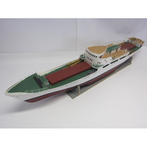 8422 - A wood and fibre glass kit built model ship finished in red, green and white, 109cm long, on stand  ... 