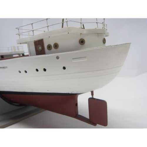 8422 - A wood and fibre glass kit built model ship finished in red, green and white, 109cm long, on stand  ... 