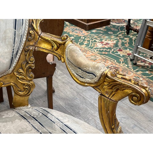 6044 - An early 20th Century French giltwood three piece suite with silk upholstery, some gilding is distre... 