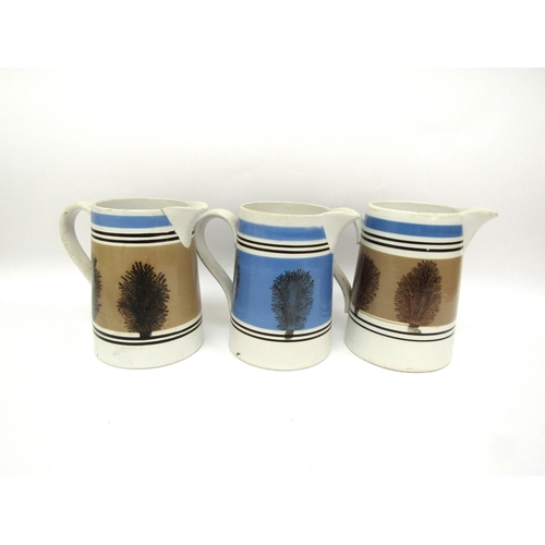 6056 - Three Quart Mocha ware jugs, one blue and two pale brown, one with crack to spout, 16cm talk