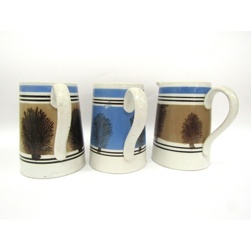 6056 - Three Quart Mocha ware jugs, one blue and two pale brown, one with crack to spout, 16cm talk