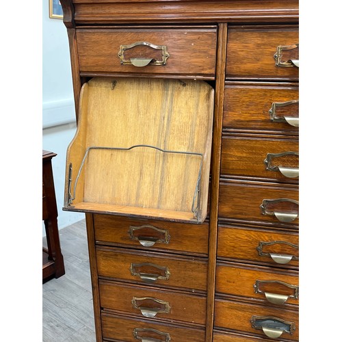 6105 - An early 20th Century oak filing cabinet set with 24 drawers, each dropping down, plinth base, 156.5... 