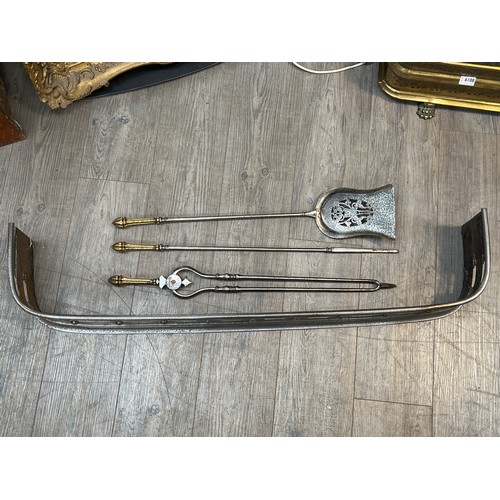 6107 - A Georgian style steel fire fender together with a set of three steel and brass handled fire irons