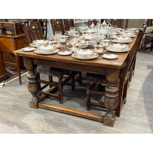 6157 - A Jacobean style country oak refectory dining table, the plank top over turned cup and cover support... 