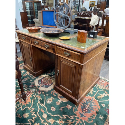 6169 - A late Victorian walnut twin pedestal desk, the green tooled leather three section top over three fr... 