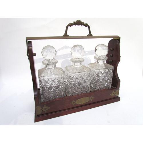 6033 - A 20th Century three bottle Tantalus, lockable with key, 36cm x 38cm