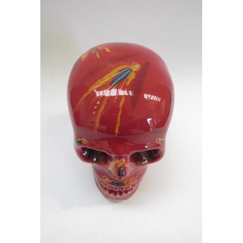 9071 - An Anita Harris Pottery skull with red and yellow glazes and blue dashes. Printed and signed marks t... 