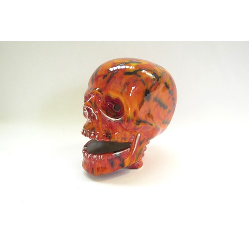 9070 - An Anita Harris Pottery skull with red and yellow glazes and black lines. Printed and signed marks t... 