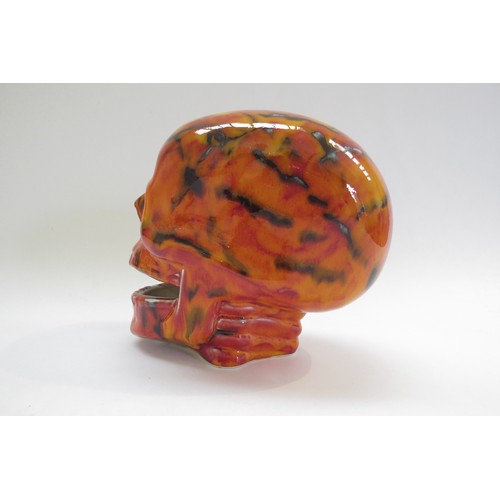 9070 - An Anita Harris Pottery skull with red and yellow glazes and black lines. Printed and signed marks t... 