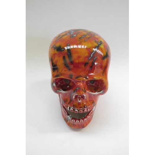 9070 - An Anita Harris Pottery skull with red and yellow glazes and black lines. Printed and signed marks t... 