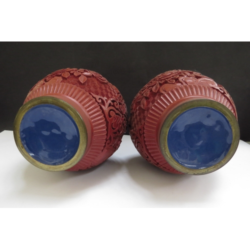 6333 - A pair of modern cinnabar and blue enamel vases, upon pierced bases, 20.5cm high