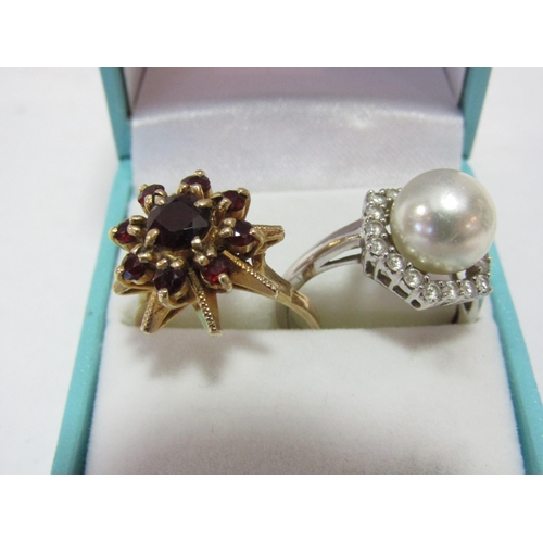 1309 - A pearl cocktail ring framed by white stones, unmarked, a 1970's style cocktail ring set with garnet... 