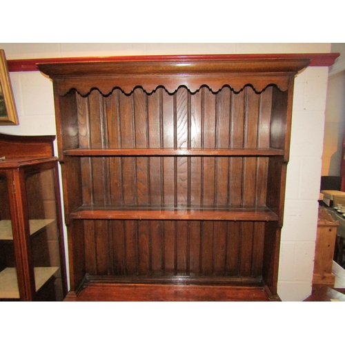 1025 - A 1920's oak full height dresser, plate rack top over a two door cupboard base, bobbin supports, 200... 