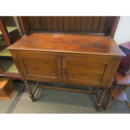 1025 - A 1920's oak full height dresser, plate rack top over a two door cupboard base, bobbin supports, 200... 