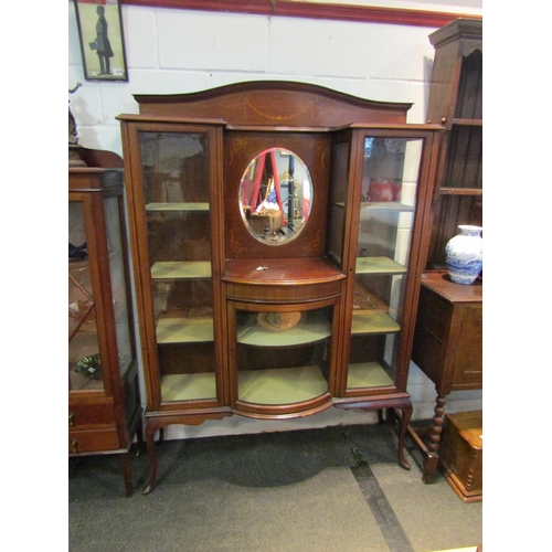 1027 - An Edwardian mahogany full height display cabinet with bow front and oval mirror, inlaid ribbon and ... 