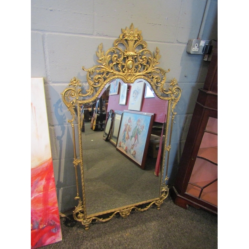 1085 - A modern classical style gilt metal wall mirror with pierced scrolled detail, urn top, 122cm x 72cm