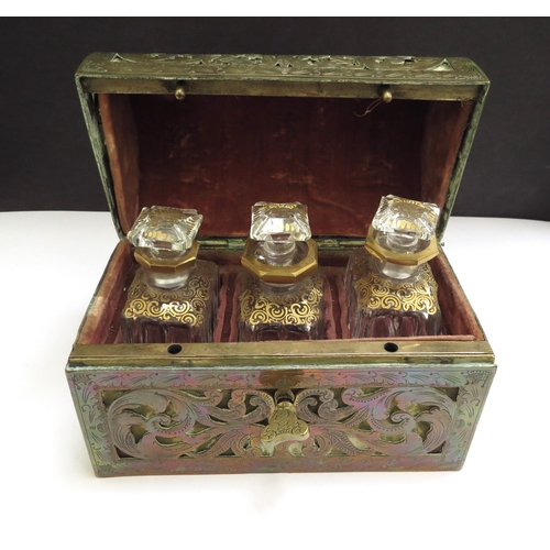 6336 - A domed shaped pierced brass velvet lined perfume casket containing three fitted cut glass perfume b... 